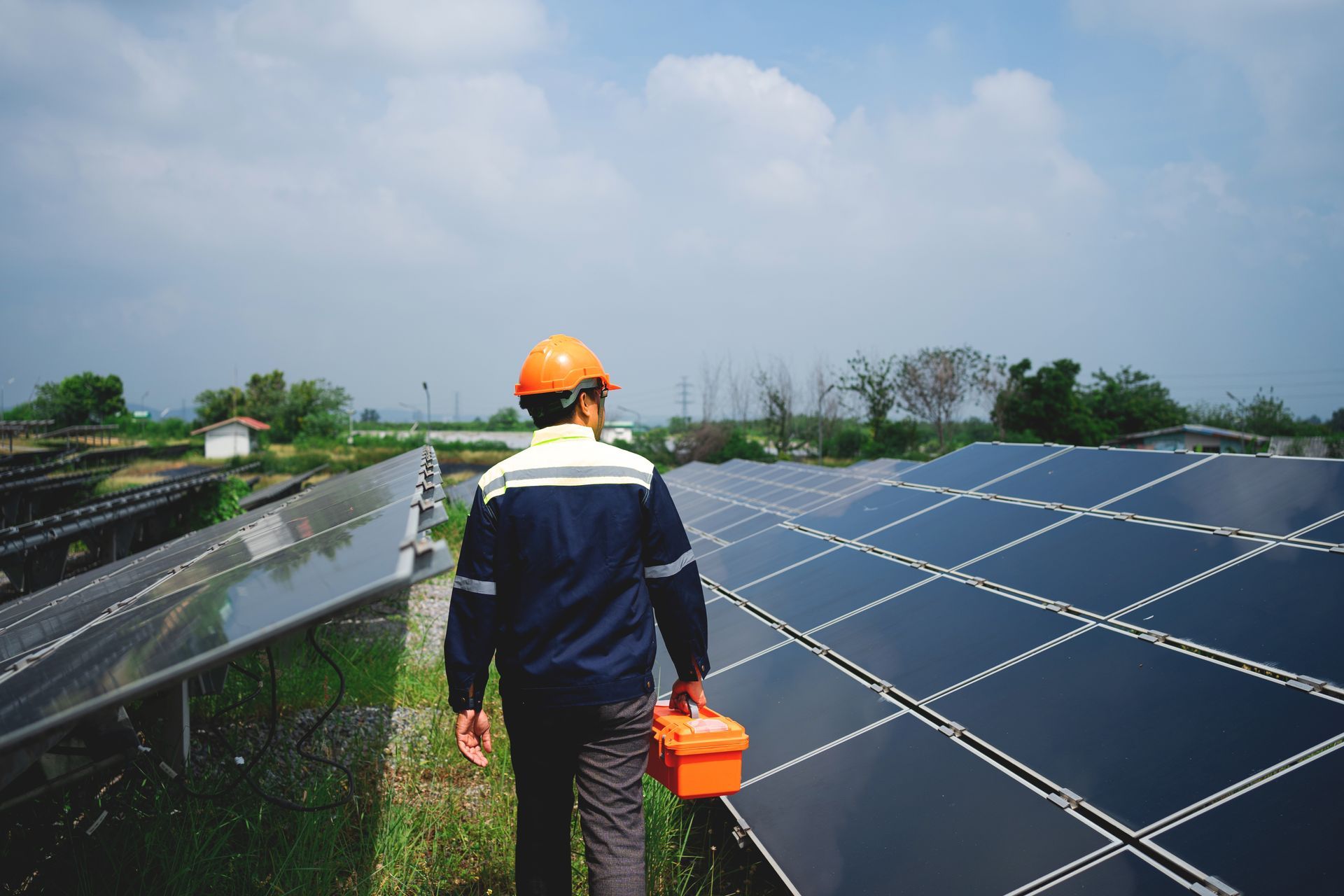 Worker in safety gear inspecting solar panels