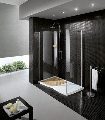 Doccia moderna con piastrelle nere, soffione a pioggia e panca integrata in un bagno elegante.