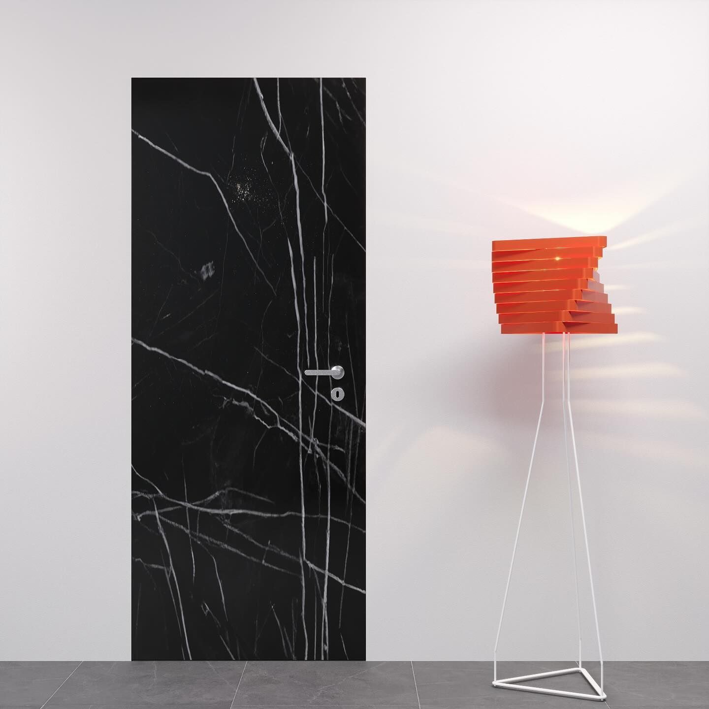 Interno moderno con porta in marmo nero e lampada da terra con paralume rosso su parete e pavimento bianchi.