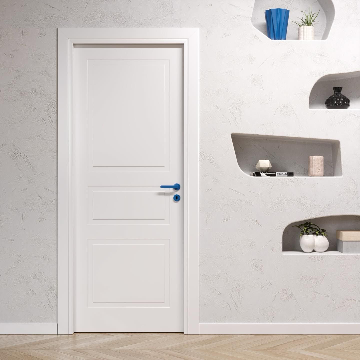 Interno minimalista bianco con porta bianca chiusa e mensole a muro integrate che ospitano piccoli oggetti decorativi.