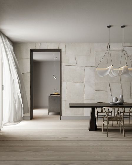 Sala da pranzo minimalista bianca con lungo tavolo, lampada a sospensione e tende trasparenti vicino a una porta.