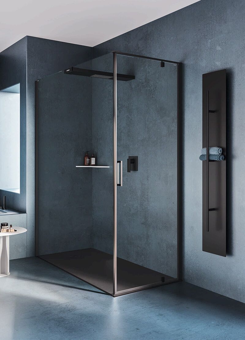 Cabina doccia in vetro con pareti in ardesia scura e mensola integrata in un bagno moderno