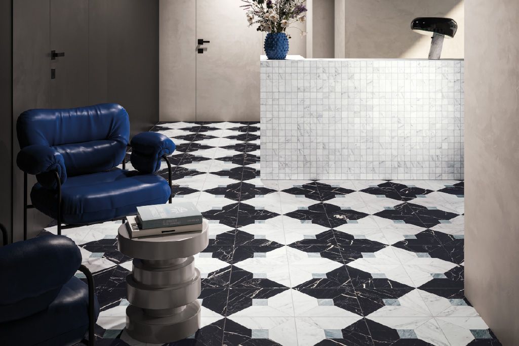 Sala relax moderna con sedie blu, pavimento a scacchi bianchi e neri e bancone reception bianco.