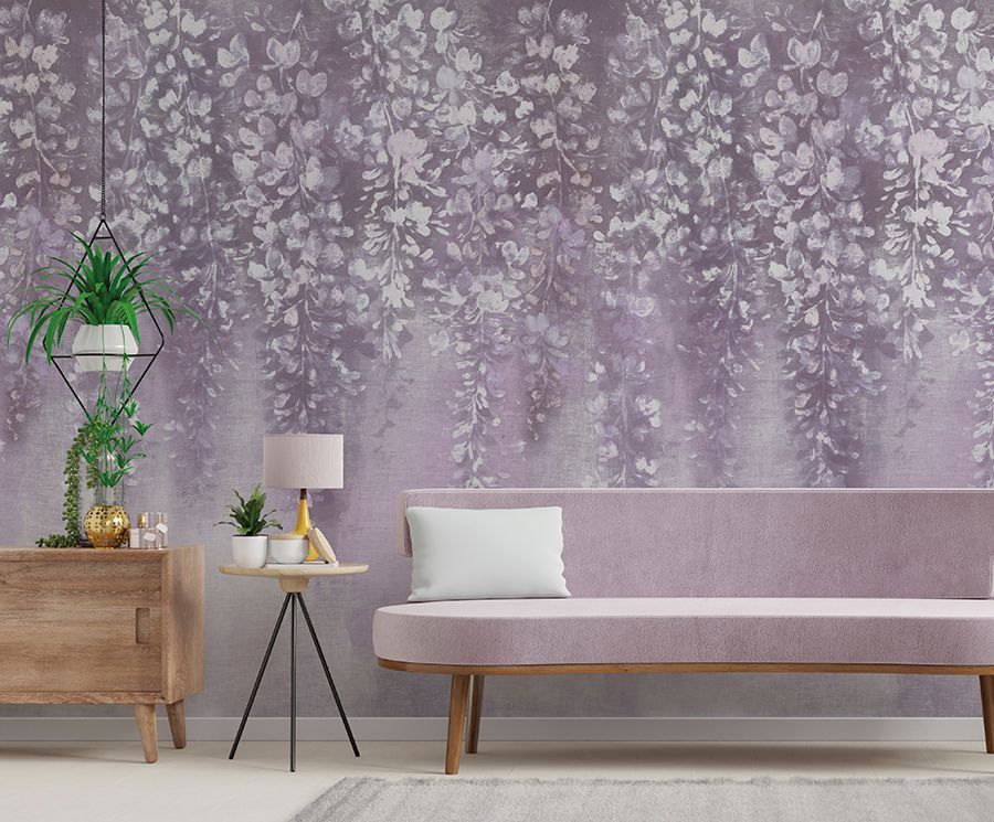 Soggiorno moderno con parete floreale color lavanda, divano rosa, credenza in legno e piante in vaso.