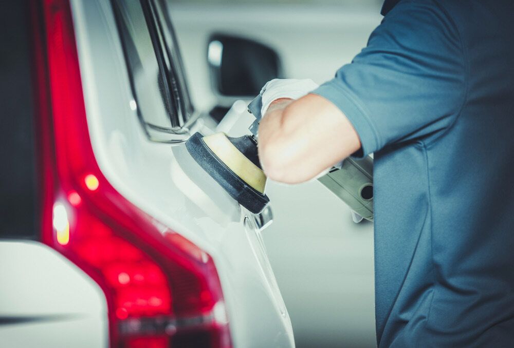 A Man Is Polishing A Car With A Machine — Country Dirt Blasters Mobile Car Detailing In Murwillumbah, NSW