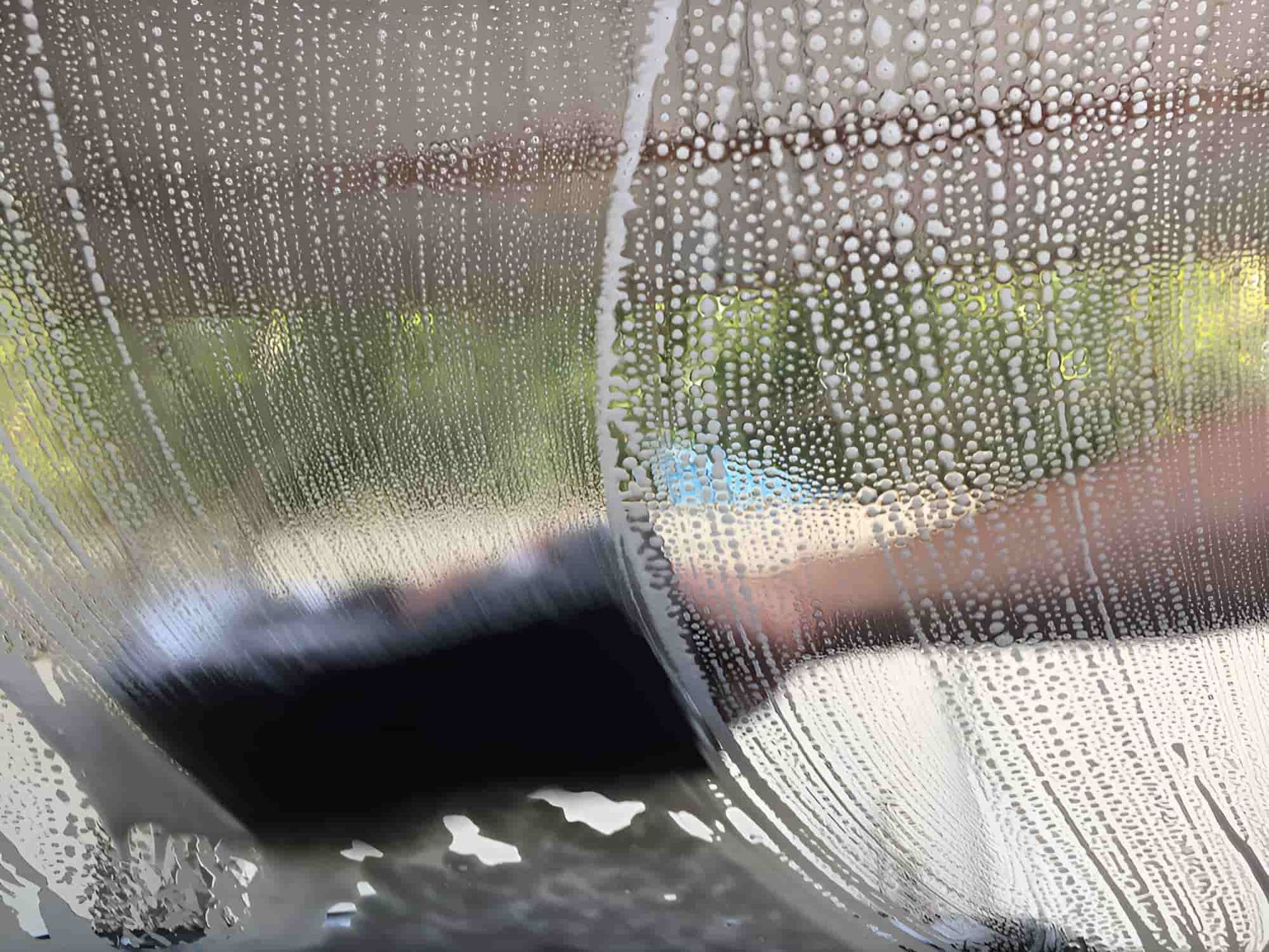 A Person Is Cleaning A Car Windshield With A Sponge — Country Dirt Blasters Mobile Car Detailing In Murwillumbah, NSW