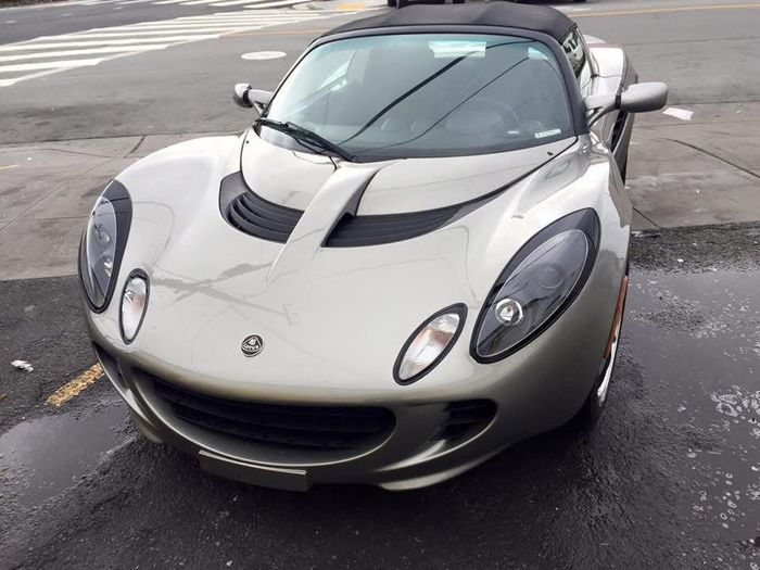 A silver sports car is parked on the side of the road