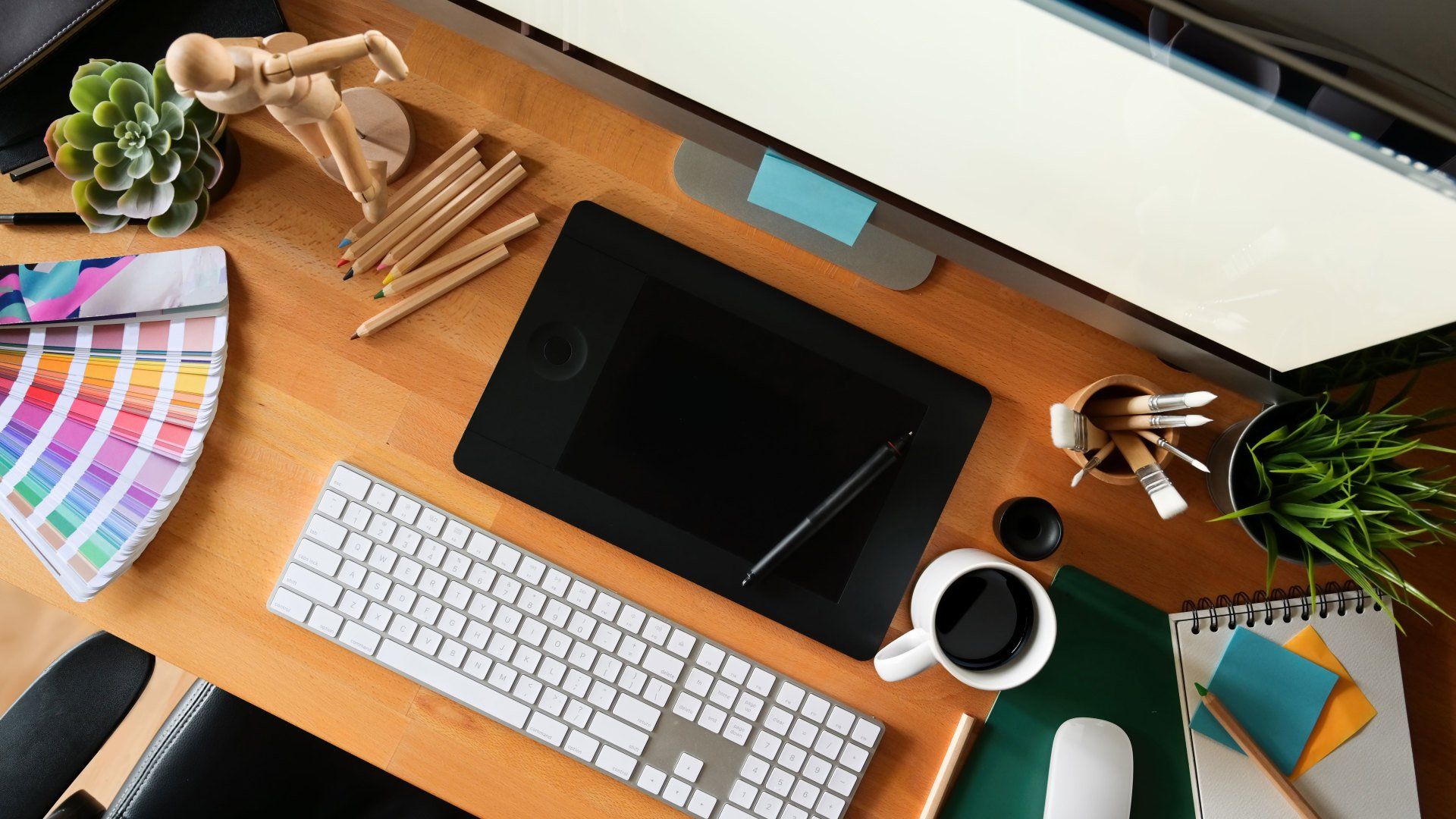Ein Schreibtisch mit Computer, Tastatur, Maus und Tablet.