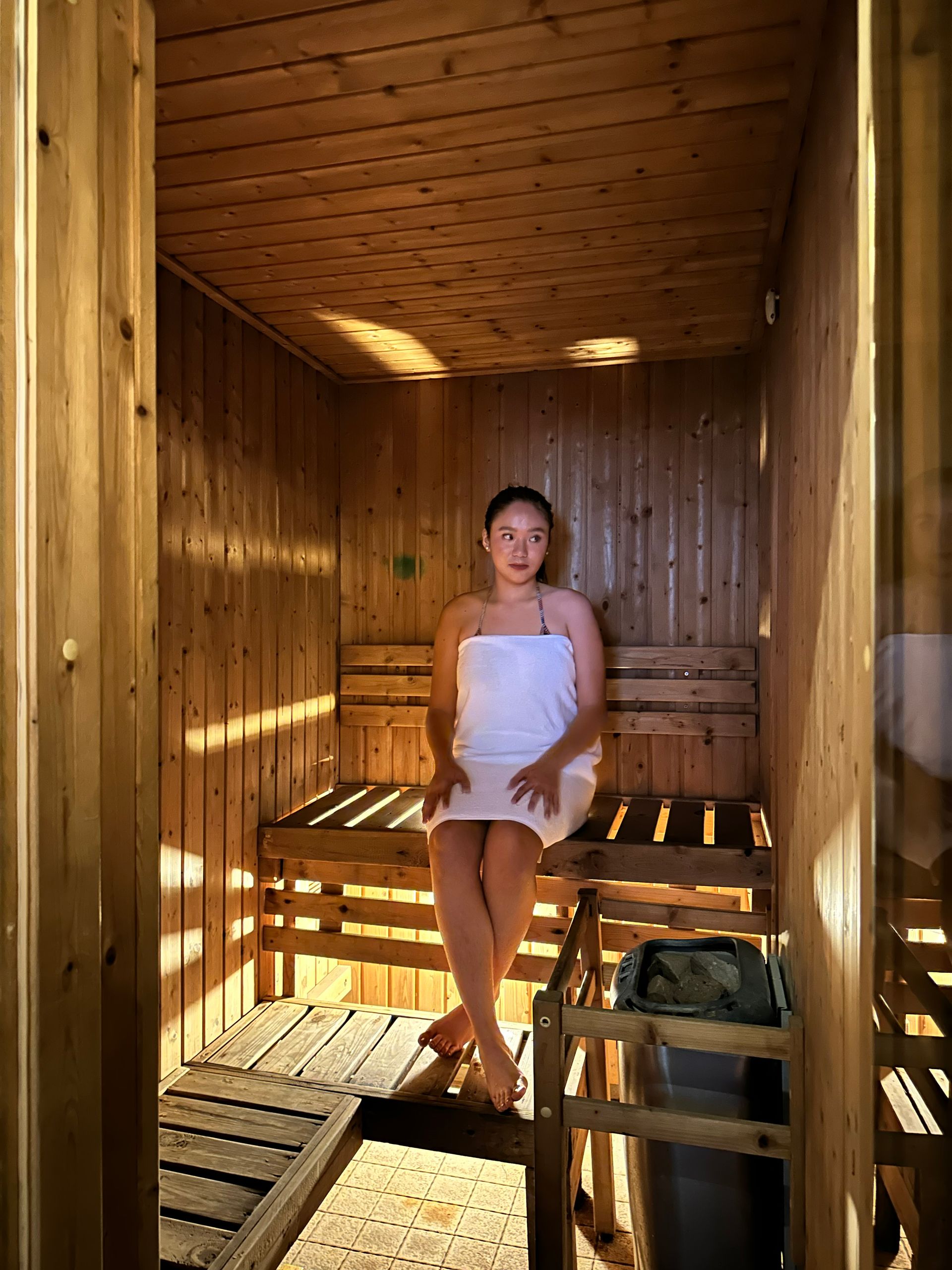 Woman relaxing in wooden sauna at The Exchange Regency Makati