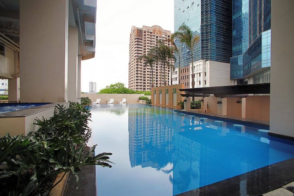 A large swimming pool is surrounded by tall buildings.