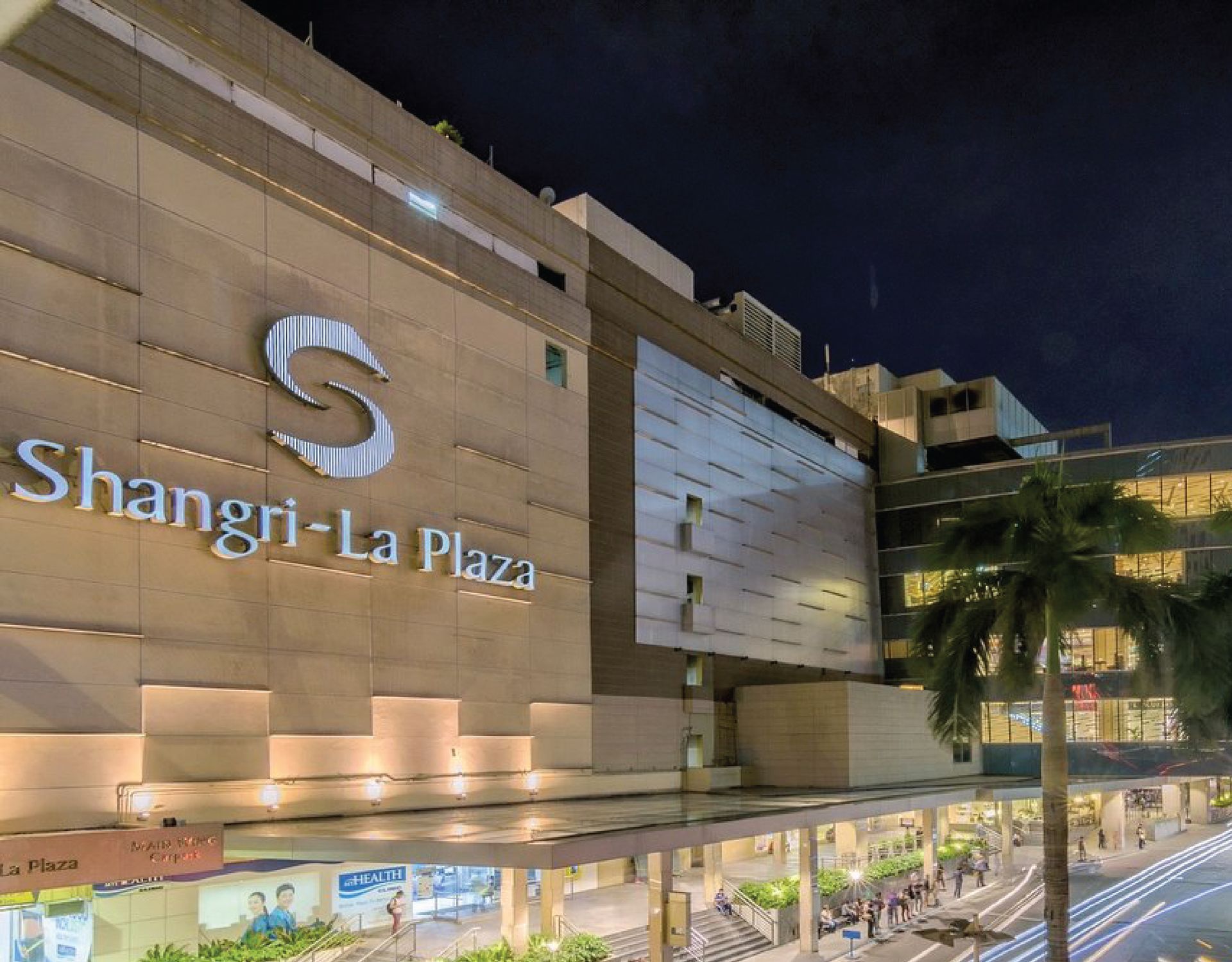Shangri-La Plaza at night, tan building with large