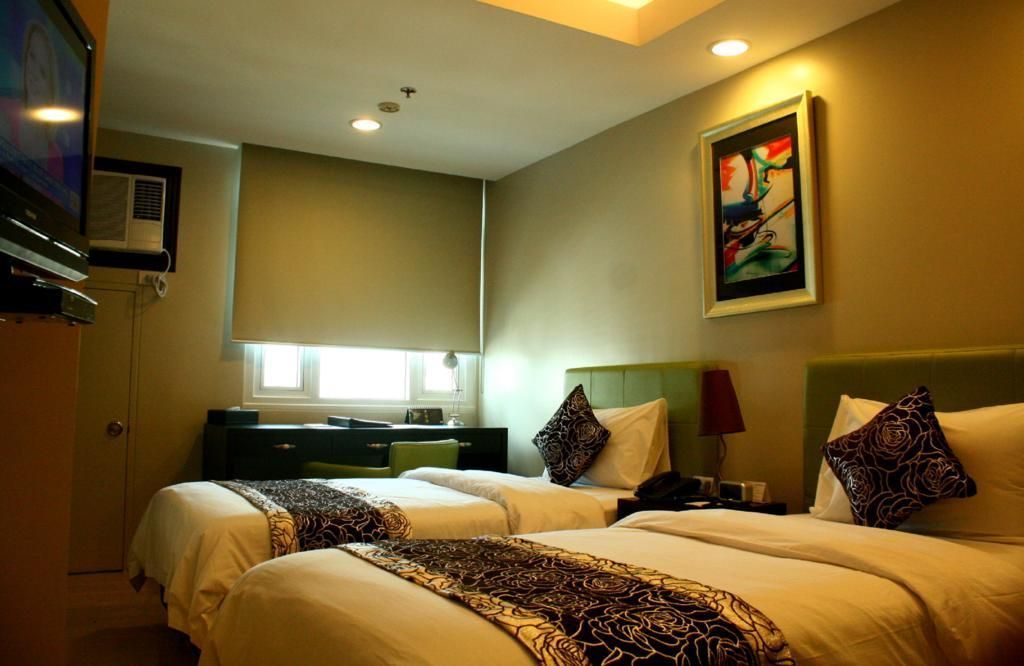 A hotel room with two beds and a flat screen tv