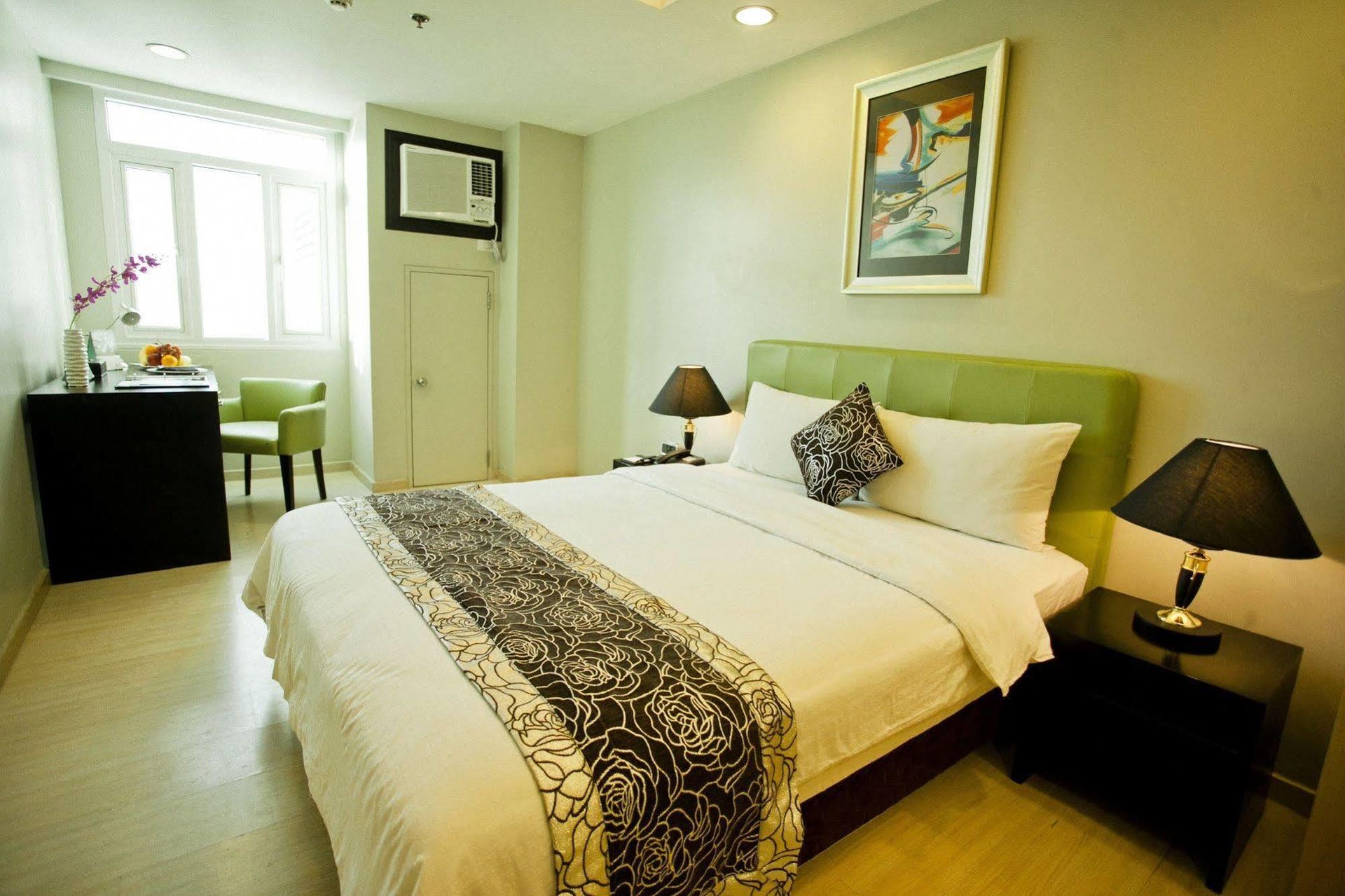 A hotel room with a large bed and two lamps