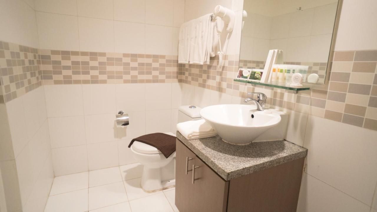 A bathroom with a sink , toilet and mirror.