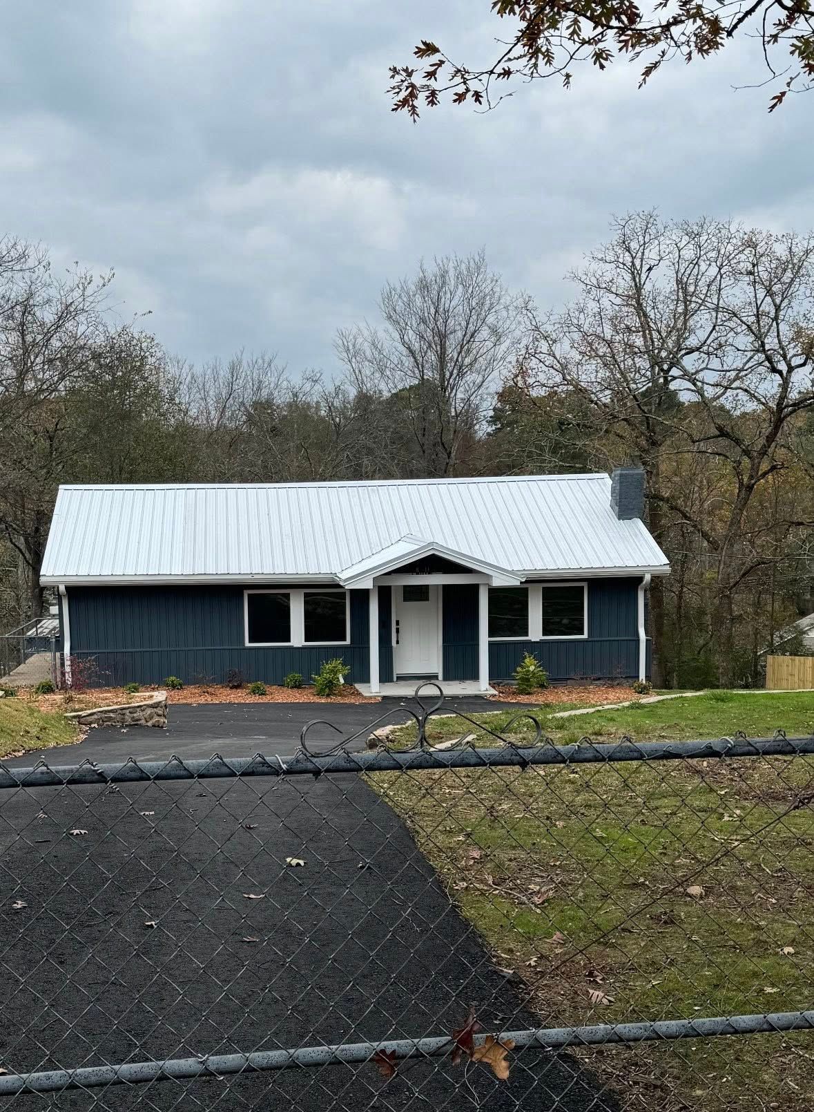A small house with a patio door and two windows.
