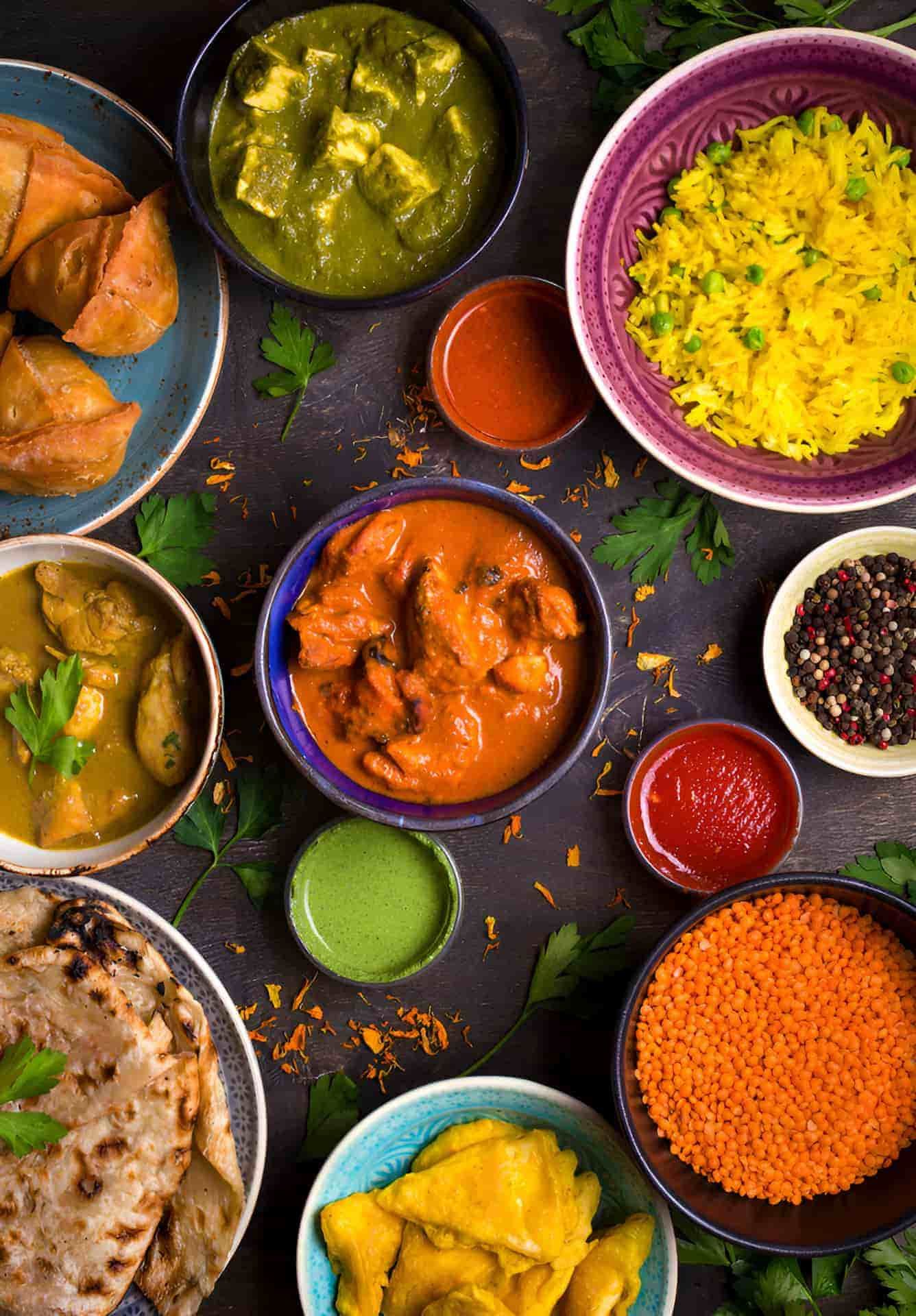 A Variety Of Indian Food In Bowls And Plates On A Table — Punjabi Sunrise Restaurant In Alexandra Hills, QLD