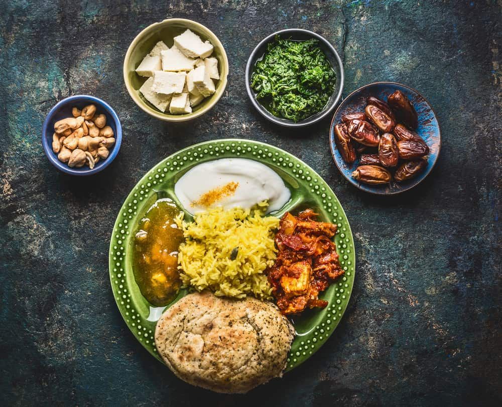 A Green Plate Topped With Rice, Eggs, Vegetables And Nuts — Punjabi Sunrise Restaurant In Alexandra Hills, QLD
