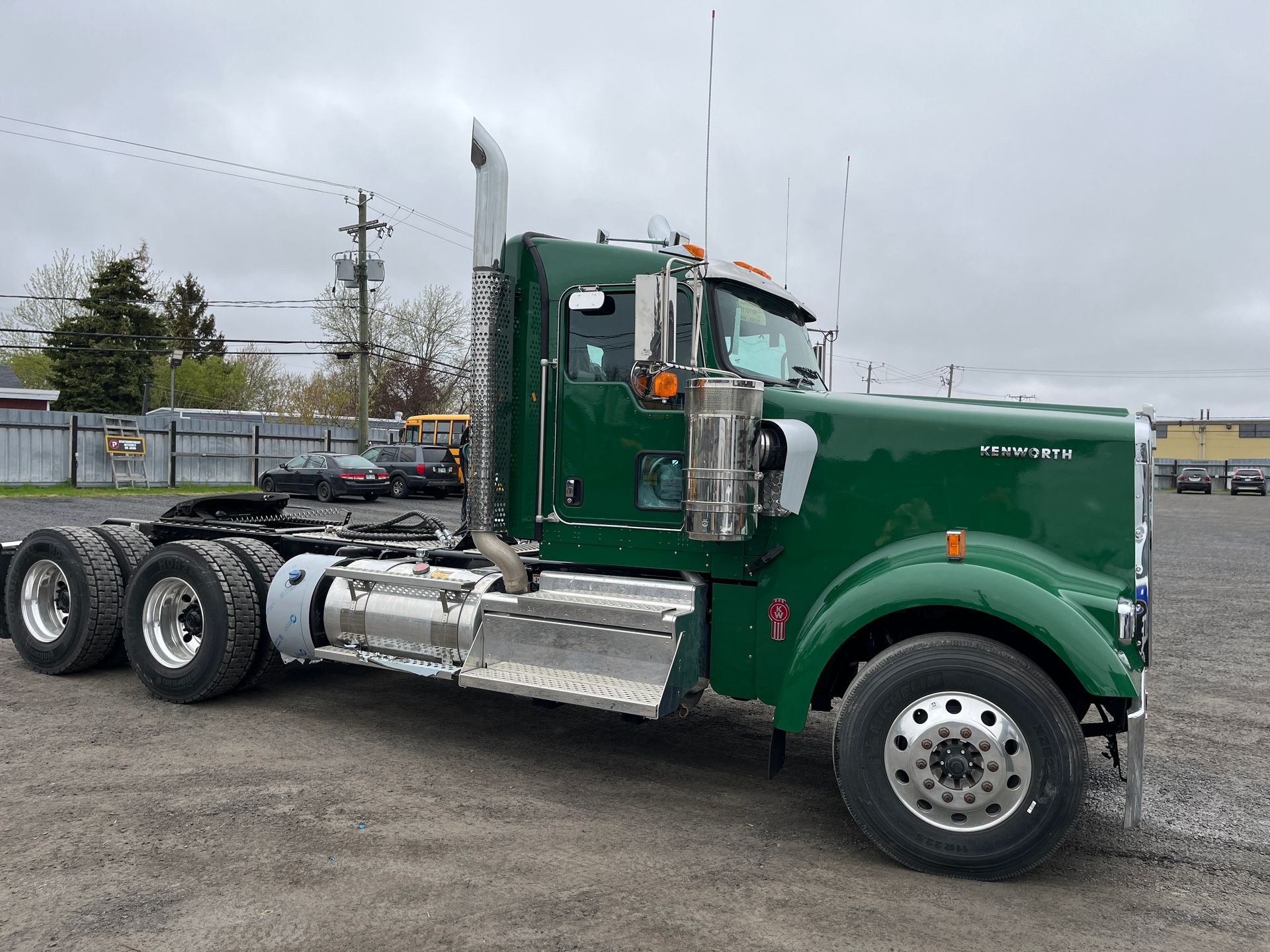 Semi-camion Kenworth vert stationné à l'extérieur par une journée nuageuse.