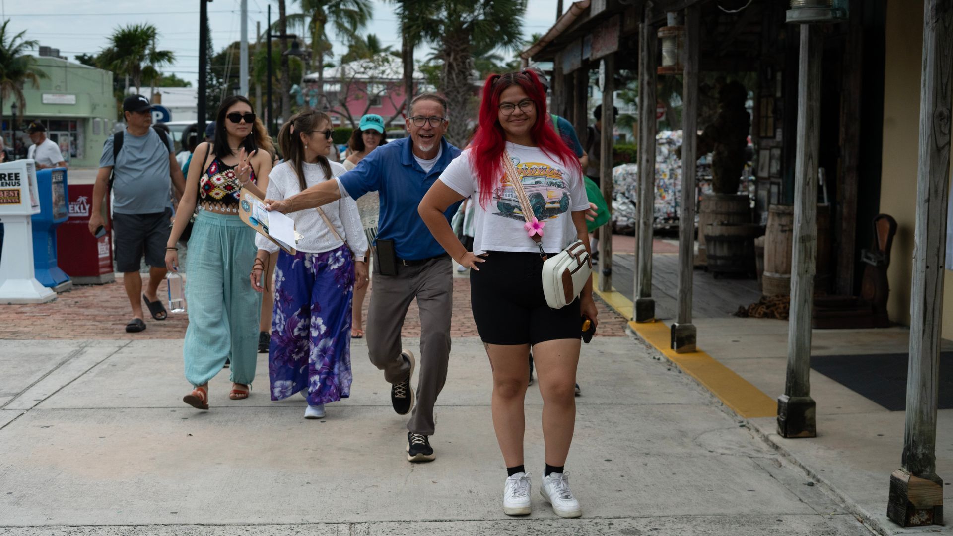 Passengers and tour guide posing for a photo, walking in Duval Street, having fun and smiling