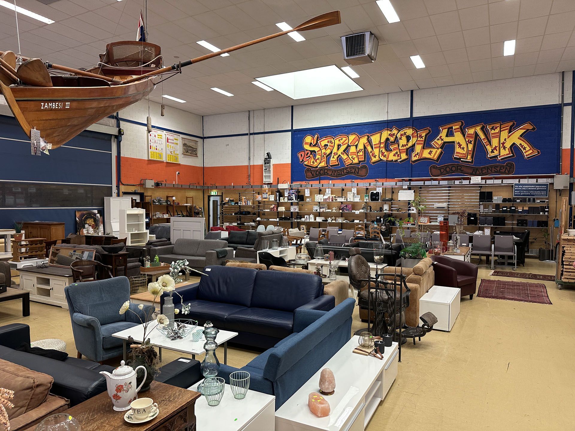 Meubelshowroom met banken, tafels en decoratie onder een groot 