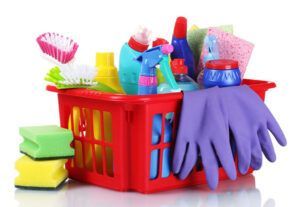 A red basket filled with cleaning supplies and gloves.