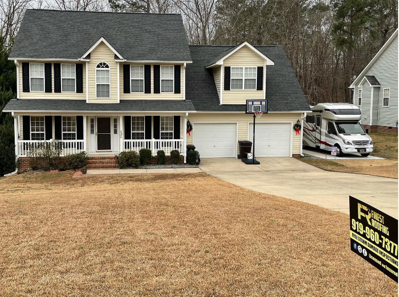 A large house with a basketball hoop and a van parked in front of it.