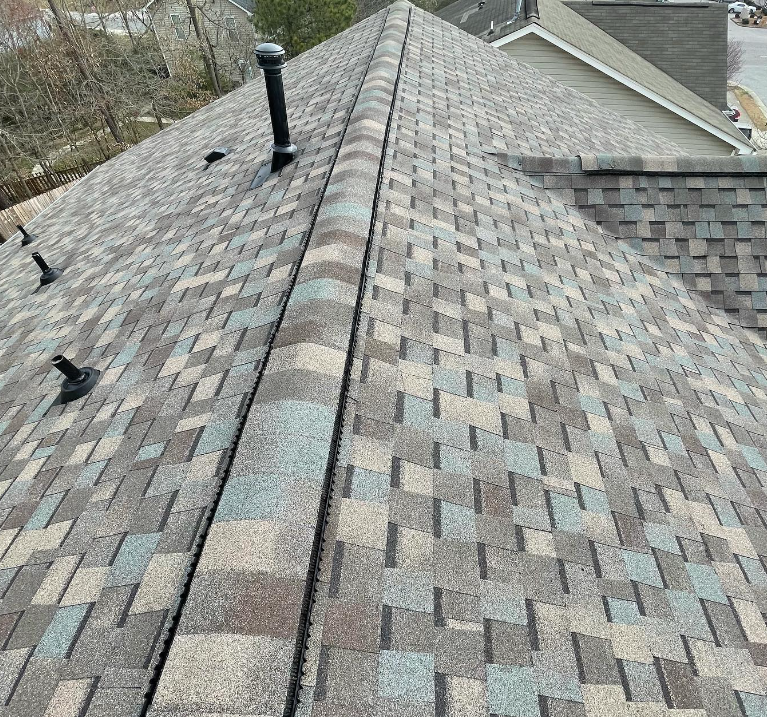 A close up of a roof with shingles and a chimney.