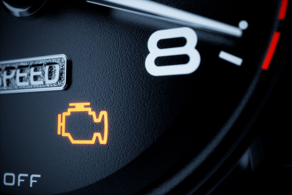 A glowing yellow check engine light symbol illuminated on a dark vehicle dashboard near a number eight.