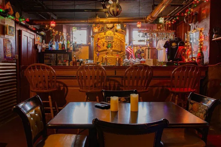 A restaurant with tables and chairs and candles on the table.