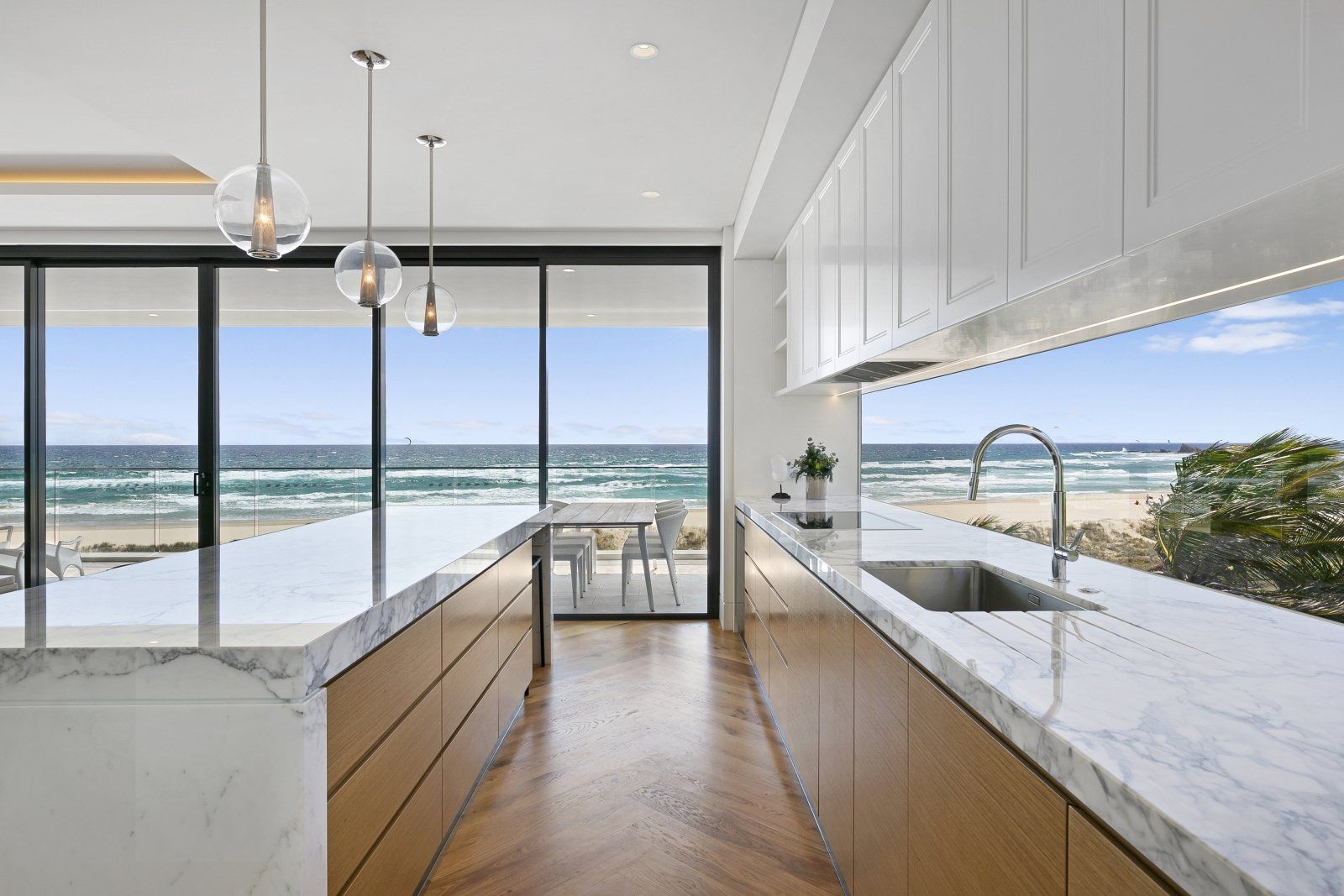 Marble Kitchen Bench with Wooden Cabinets in Front of Beach — Interior Design in Tweed Heads, NSW