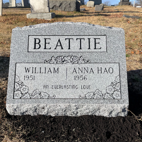 A double-slant gravestone for a married couple.