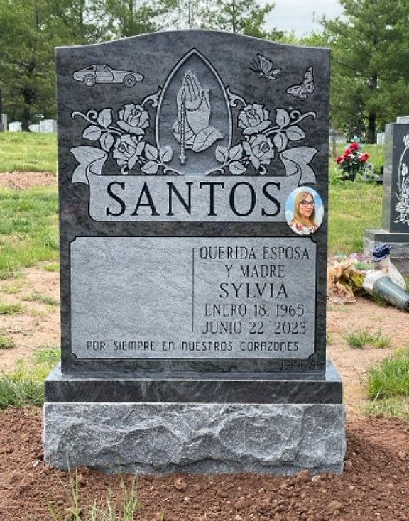 A gray granite headstone in a cemetery. 