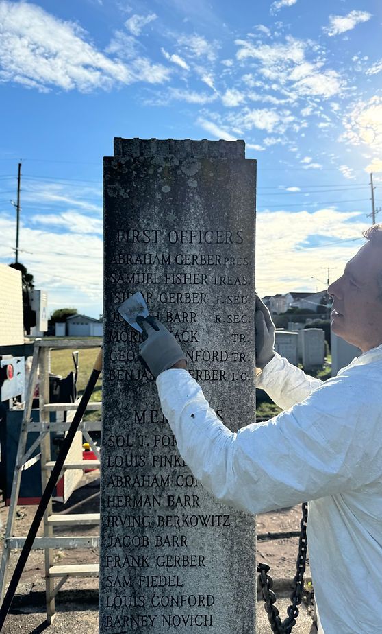 A monument black with mold before restoration