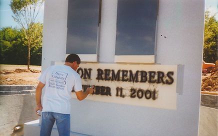Worker prepping the stencil for a 9/11 memorial depicting the twin towers.