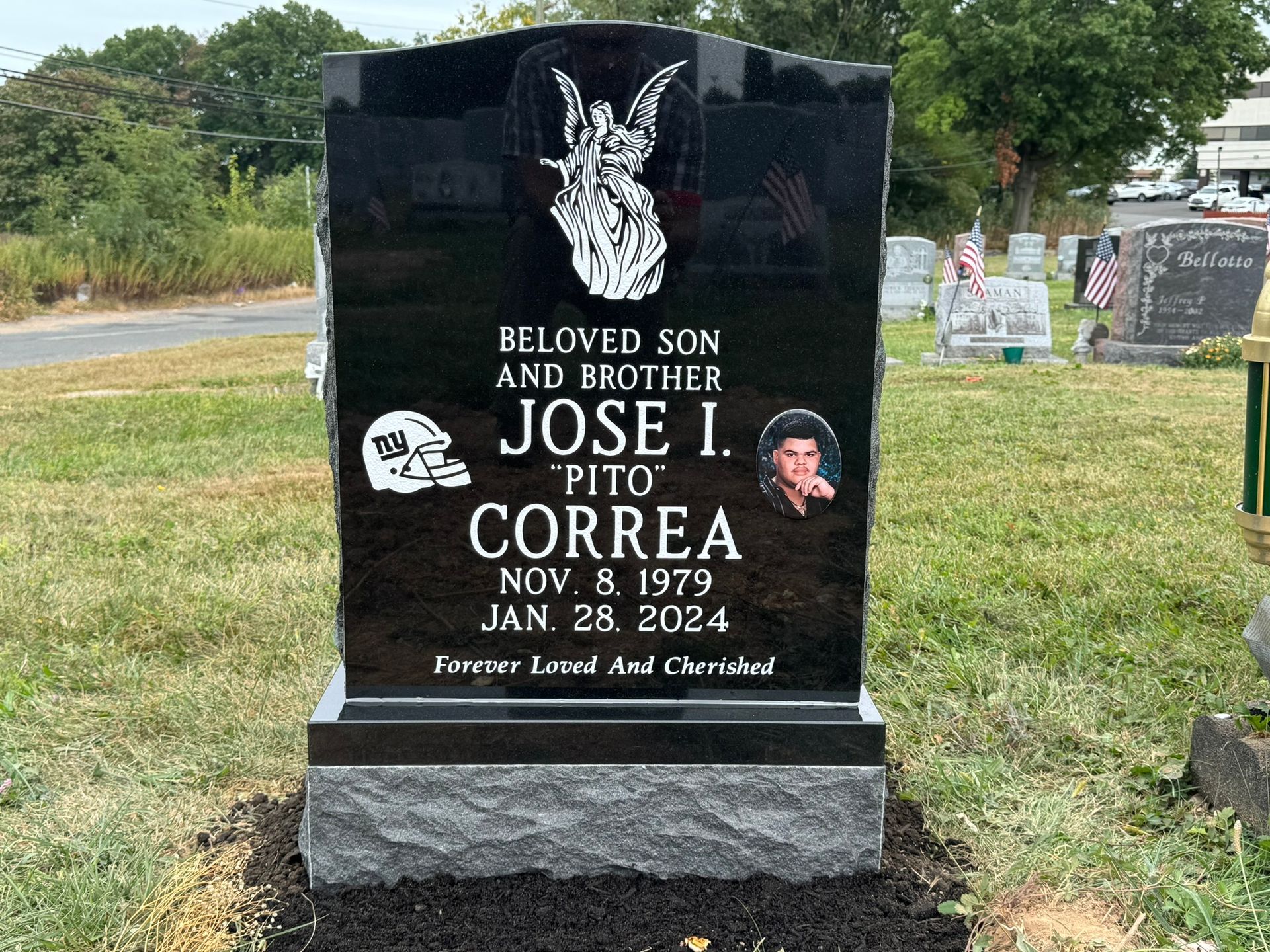 A black headstone with a laser-etched image of the deceased and a NY Jets helmet