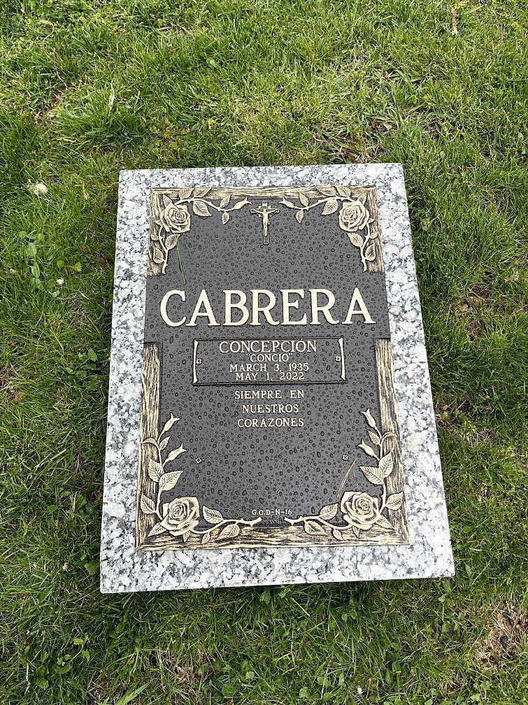 A bronze memorial with a crucifix and floral designs