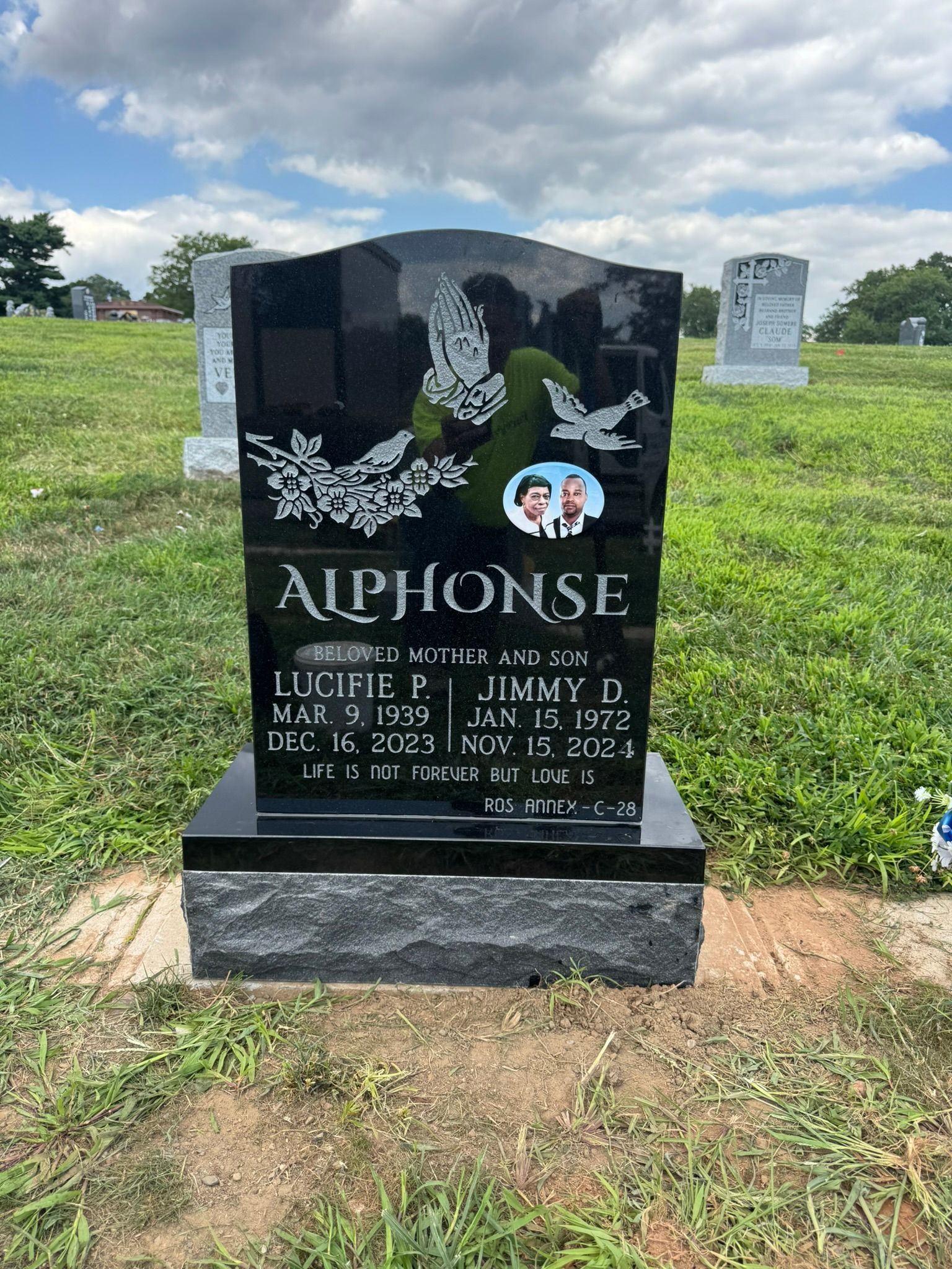 Black headstone with a digitized portrait of the deceased couple