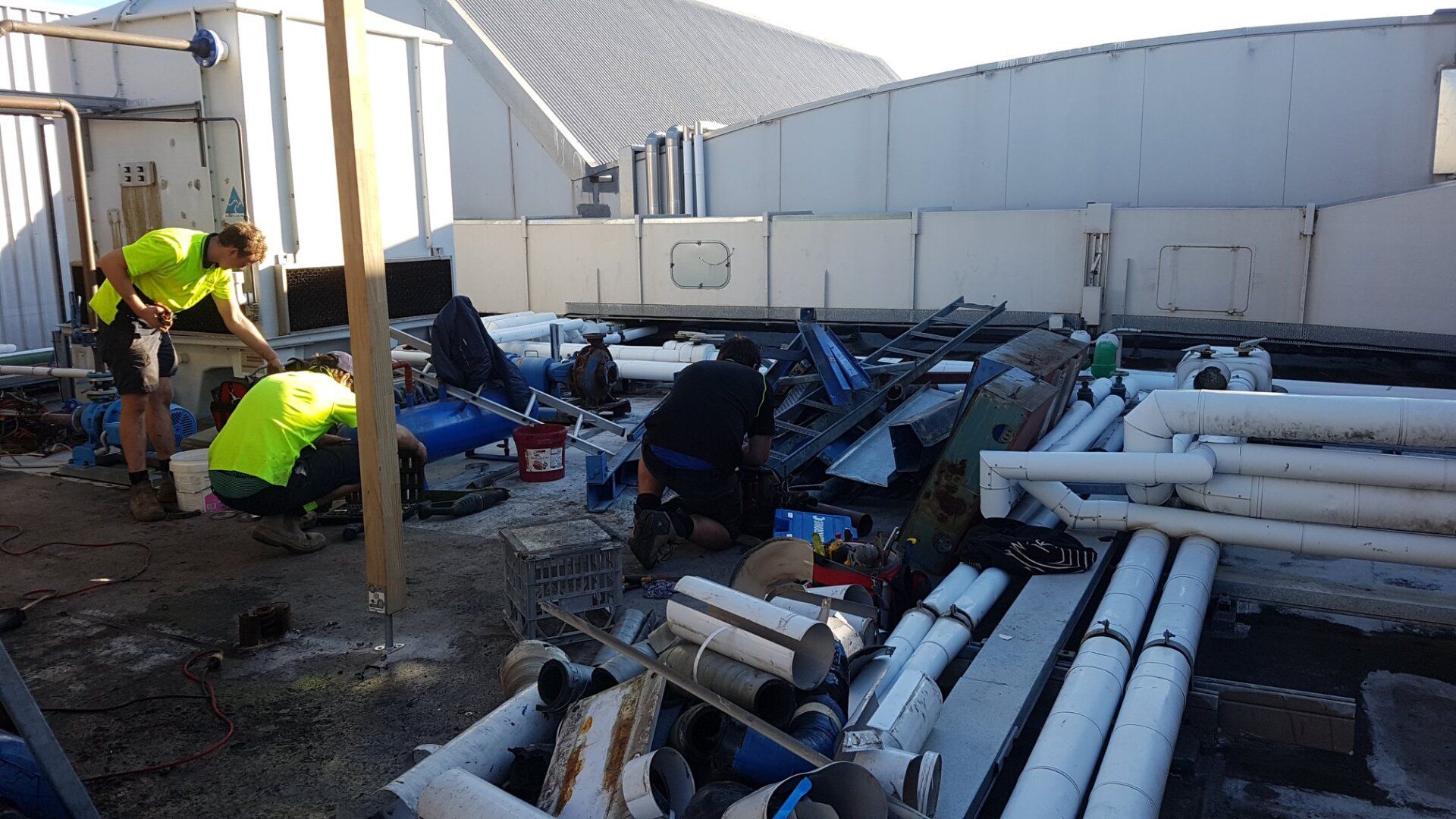 Technicians Installing Inverter Air Conditioner on a  Roof — Newcastle Air & Refrigeration In New Lambton, NSW