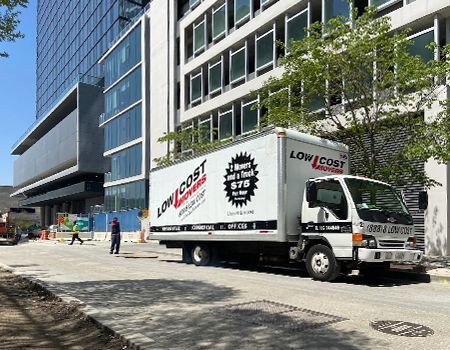 Moving truck parked next to a modern building;