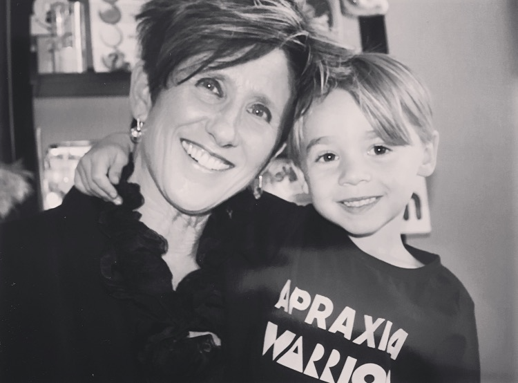 Woman with arm around a child wearing 