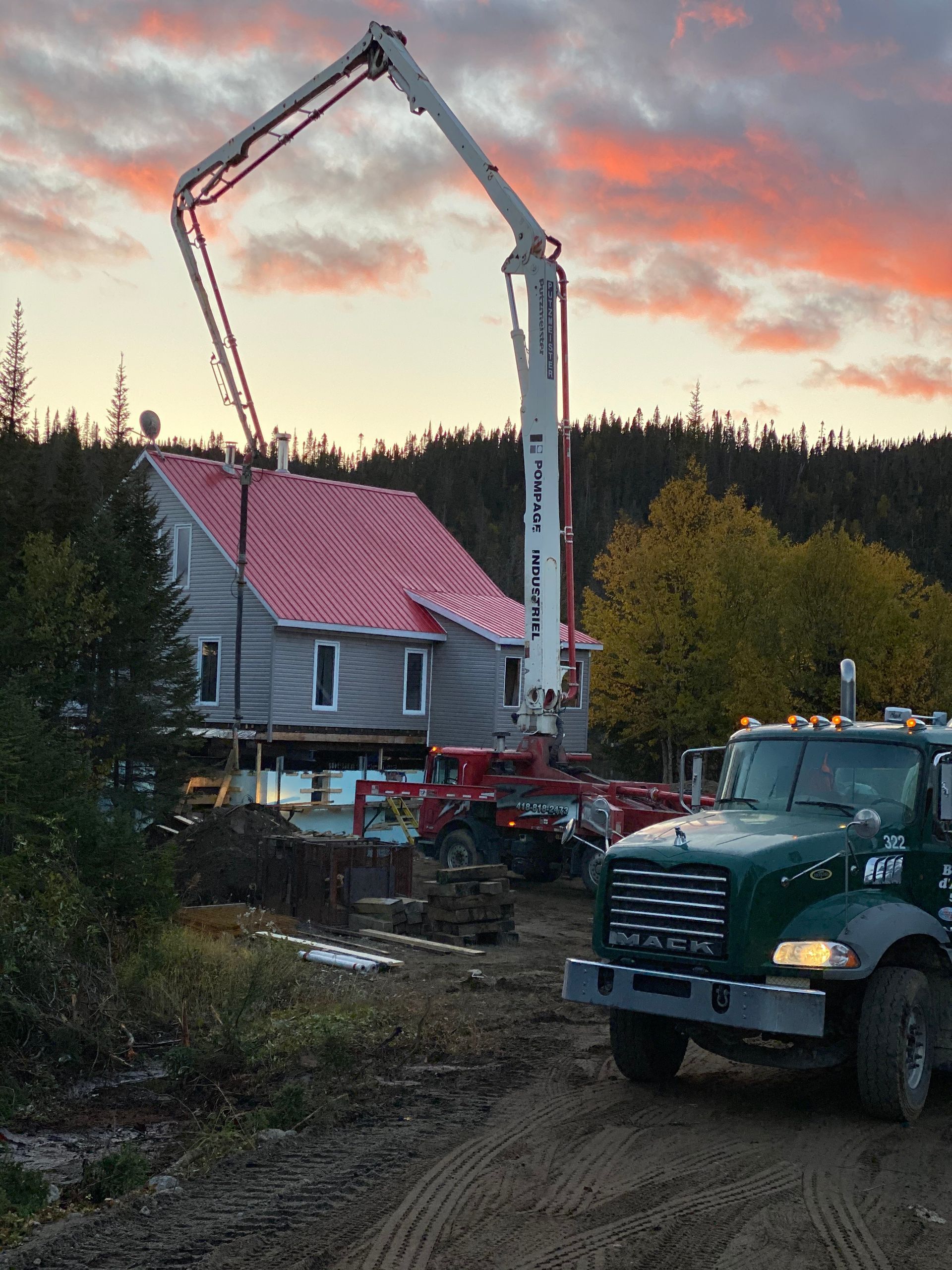Un camion Mack est garé devant une maison en construction