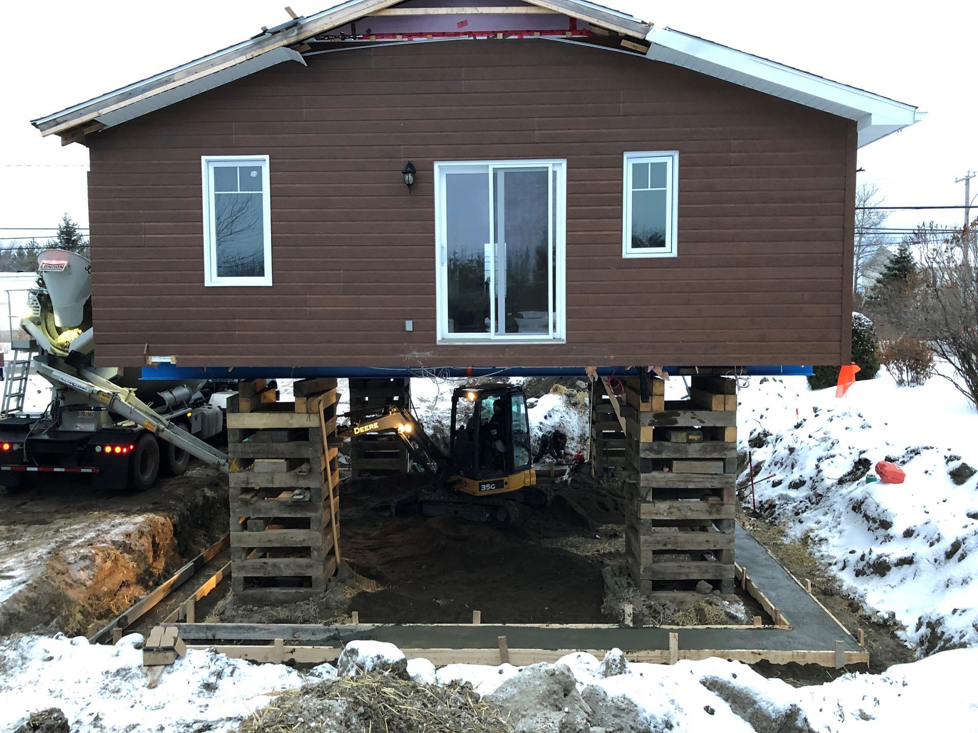 Une maison est en construction sur pilotis dans la neige
