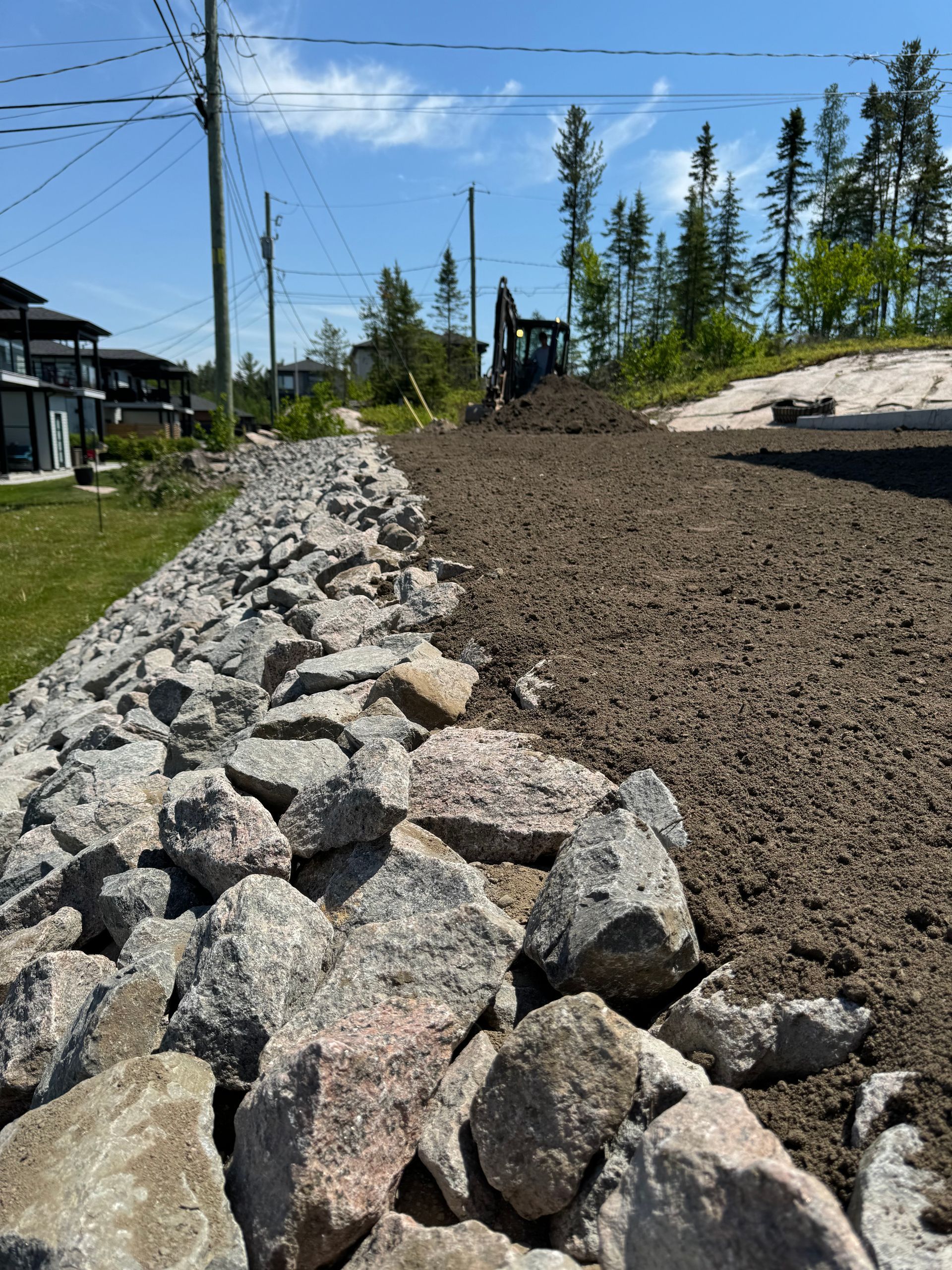 Un gros tas de rochers se trouve au milieu d'un chemin de terre.