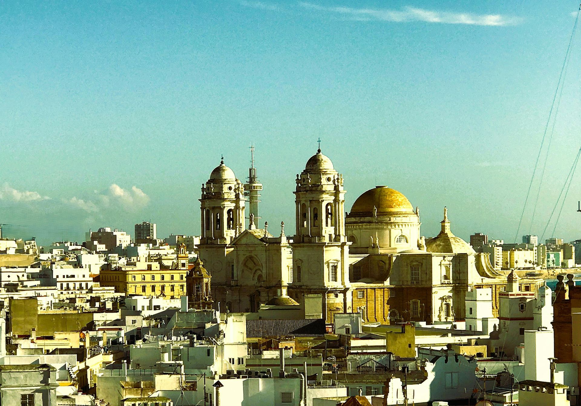 Catedral de cúpula dorada y horizonte urbano bajo un cielo azul despejado.