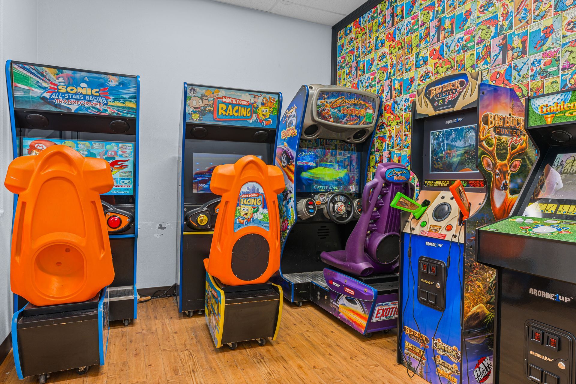 Lucent Orthodontics, San Antonio. A row of four arcade game cabinets in a brightly lit room with a colorful comic book-themed wall.