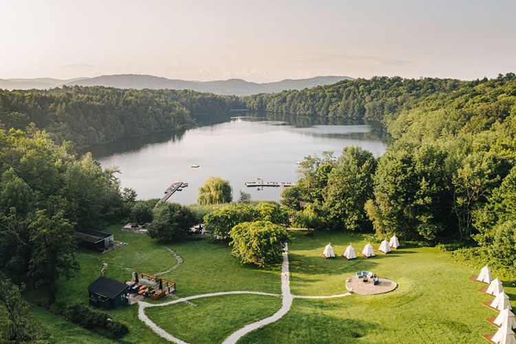 An aerial view of a lake surrounded by trees and grass.