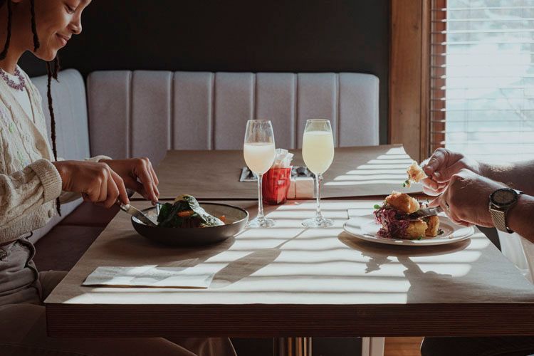 Deux personnes sont assises à une table en train de manger et de boire.
