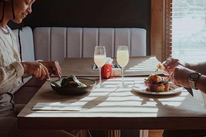 Deux personnes sont assises à une table en train de manger et de boire.