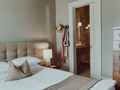 Une chambre d'hôtel avec un lit et deux portes coulissantes ouvertes.