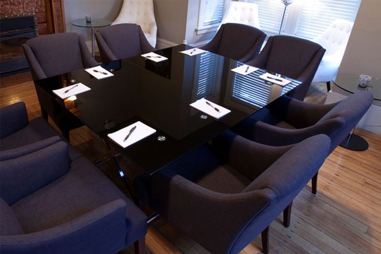 Une salle de conférence avec une table et des chaises noires et un foyer.